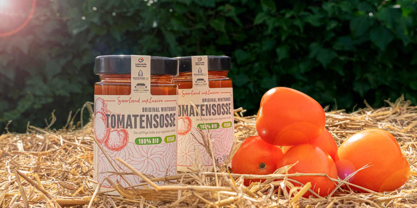 Zwei Gläser der Saarland inklusive-Tomatensuppe auf einem Strohballen